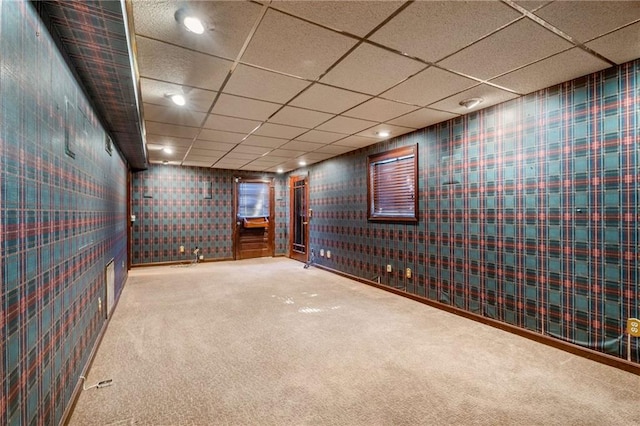 below grade area with wallpapered walls, recessed lighting, carpet, and a paneled ceiling