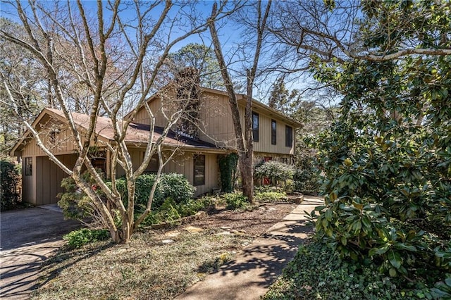 view of home's exterior with aphalt driveway, a garage, and a chimney