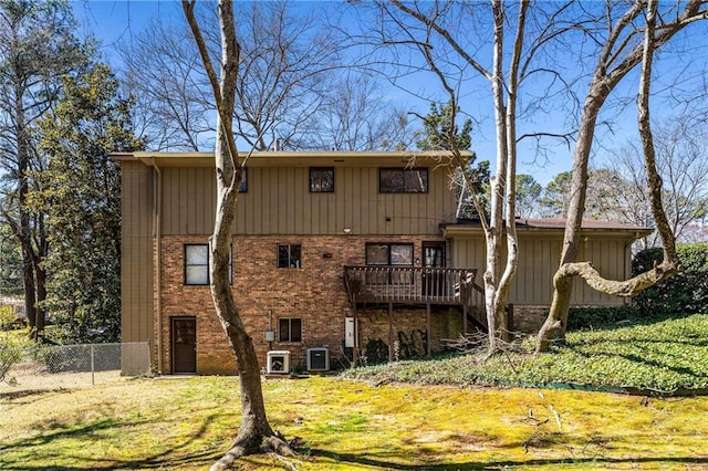 back of property featuring brick siding, central AC unit, a yard, and fence