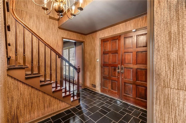 foyer entrance with wallpapered walls, baseboards, a chandelier, stairway, and ornamental molding