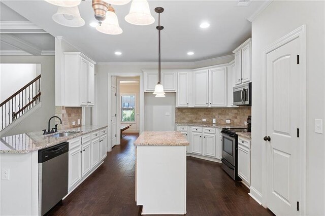 kitchen with white cabinets, stainless steel appliances, a center island, and hanging light fixtures