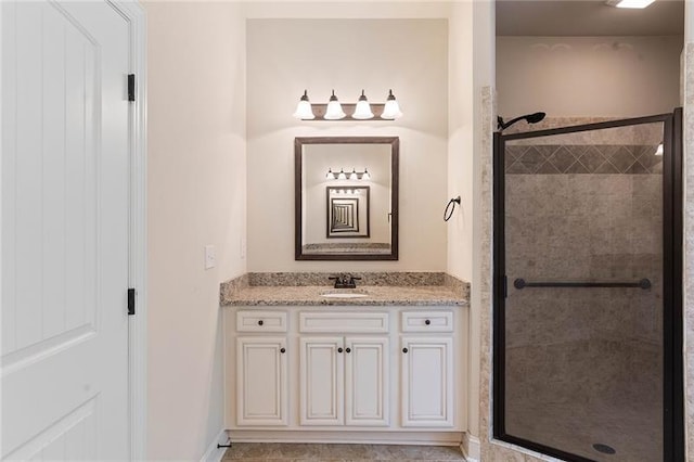 bathroom with a shower with shower door and vanity