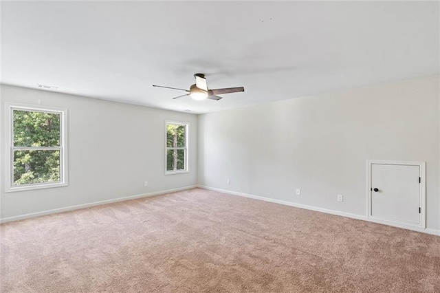 empty room with ceiling fan and light carpet