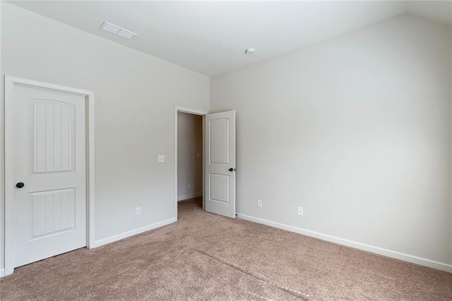 unfurnished bedroom with light carpet and vaulted ceiling