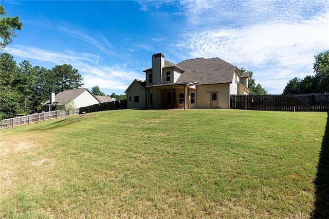 rear view of property with a yard