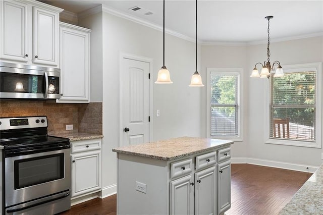 kitchen featuring white cabinets, decorative light fixtures, light stone counters, and appliances with stainless steel finishes