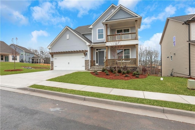 craftsman house with a garage, a balcony, a front yard, and covered porch