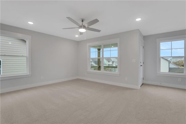 carpeted spare room with ceiling fan and plenty of natural light