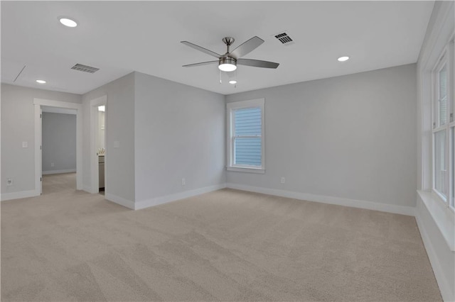 empty room with light carpet, plenty of natural light, and ceiling fan