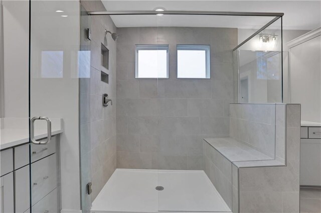 bathroom featuring tile patterned floors, a shower with door, and vanity