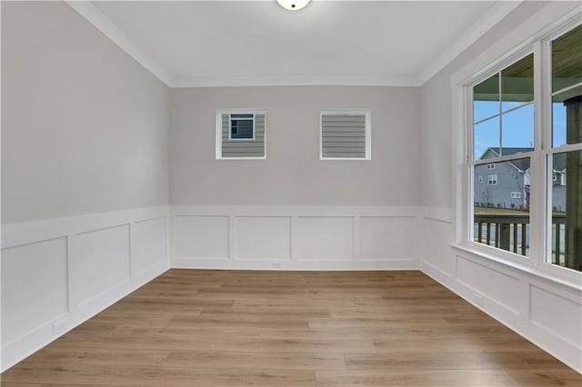 empty room featuring light hardwood / wood-style flooring and crown molding