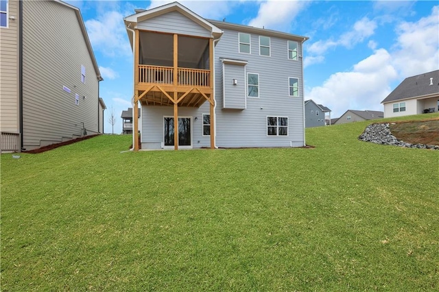 back of house featuring a sunroom and a lawn