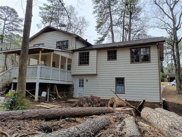 rear view of property with a sunroom and stairway