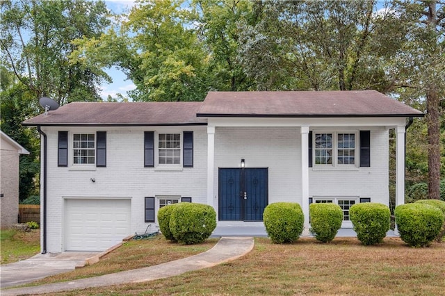 split foyer home featuring a front lawn and a garage