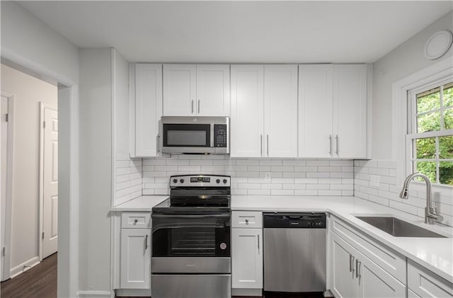 kitchen with white cabinetry, sink, and stainless steel appliances