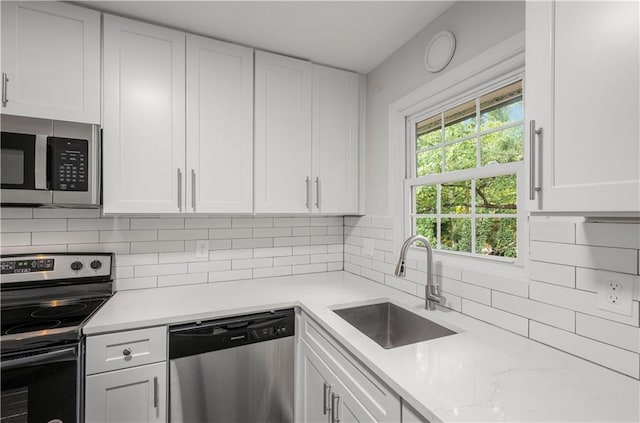 kitchen featuring appliances with stainless steel finishes, white cabinetry, sink, and plenty of natural light