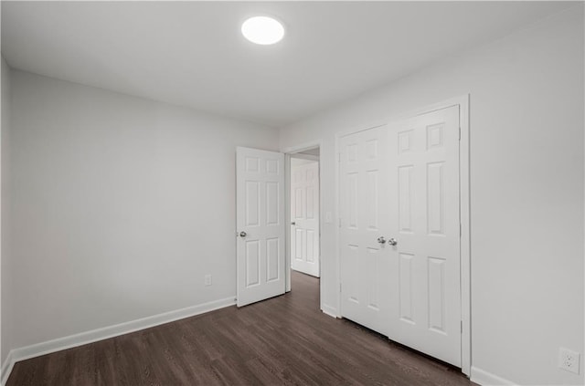 unfurnished bedroom featuring dark wood-type flooring and a closet