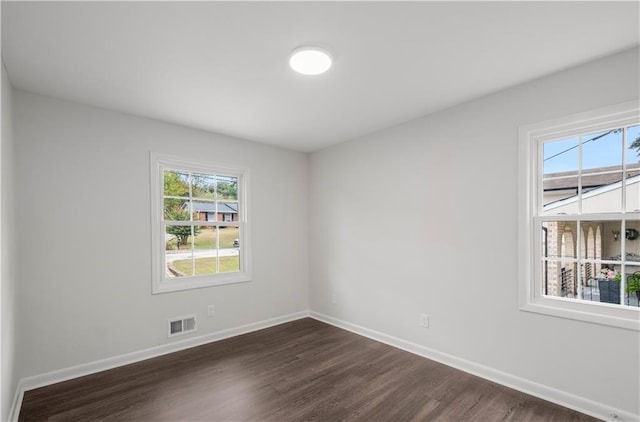 unfurnished room with dark wood-type flooring