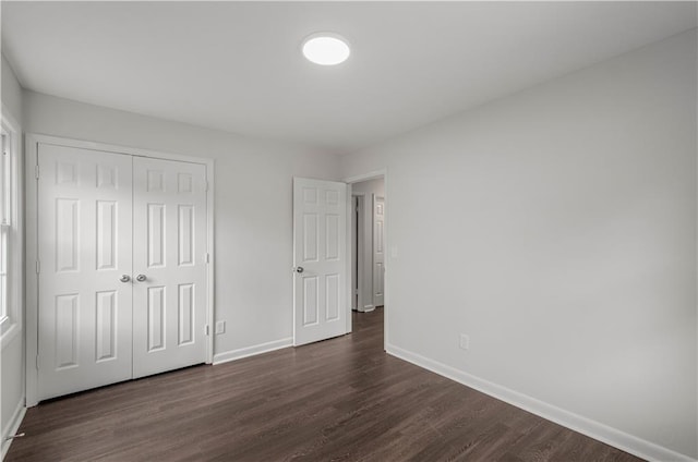 unfurnished bedroom featuring a closet and dark hardwood / wood-style floors