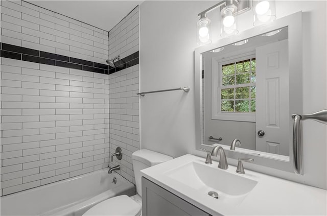 full bathroom with tiled shower / bath, vanity, and toilet