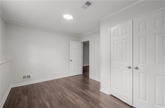 unfurnished bedroom featuring a closet, crown molding, and dark hardwood / wood-style flooring