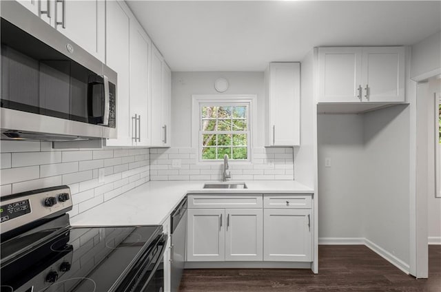 kitchen with sink, white cabinetry, stainless steel appliances, dark hardwood / wood-style floors, and decorative backsplash