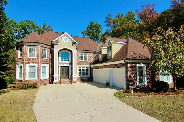 view of front of property featuring a front lawn, driveway, french doors, a garage, and brick siding