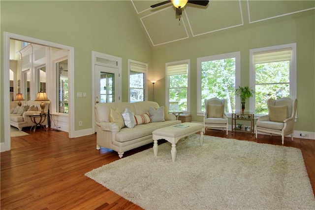 living room featuring ceiling fan, high vaulted ceiling, and dark hardwood / wood-style flooring