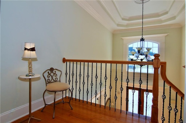 interior space featuring crown molding, hardwood / wood-style flooring, a raised ceiling, and a chandelier