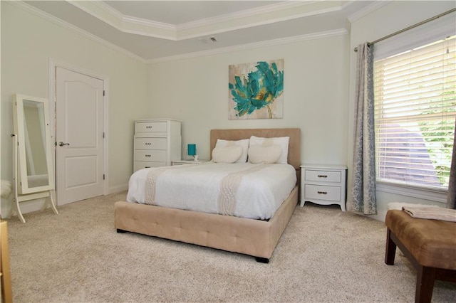 carpeted bedroom with ornamental molding and a tray ceiling