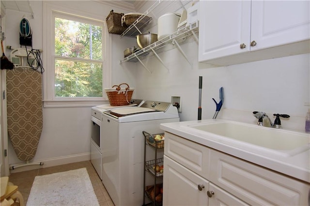 laundry area featuring sink, light tile patterned flooring, cabinets, and separate washer and dryer