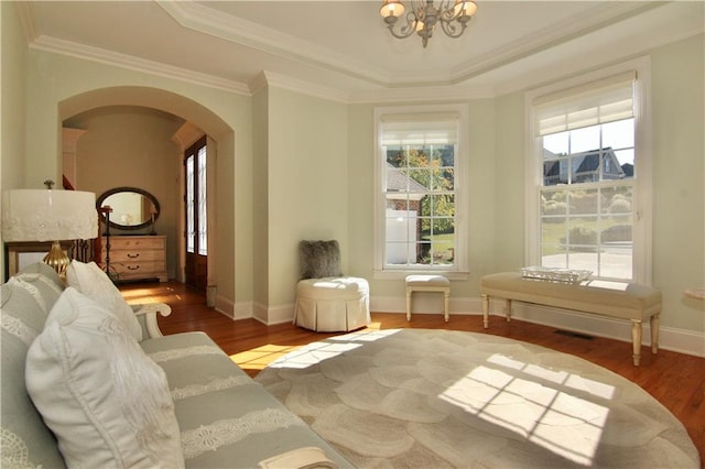 sitting room featuring crown molding, hardwood / wood-style flooring, a raised ceiling, and a chandelier