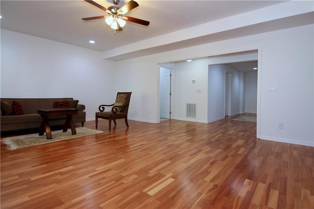 living room featuring hardwood / wood-style floors and ceiling fan