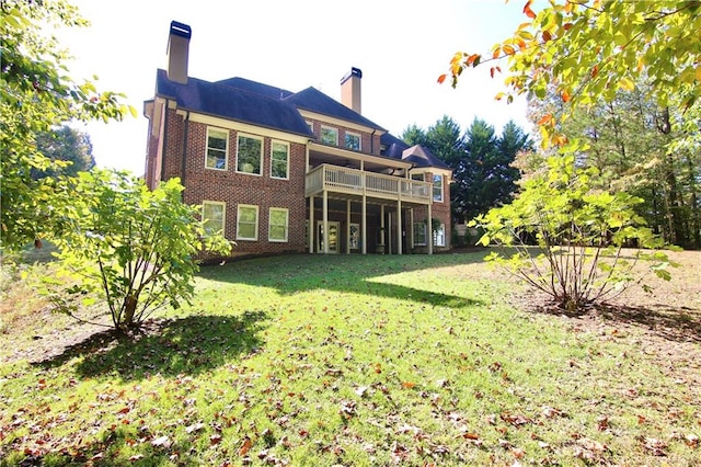 rear view of property with a deck and a yard