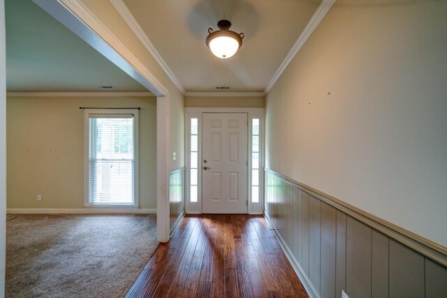 foyer with ornamental molding, dark wood-style flooring, and a wainscoted wall