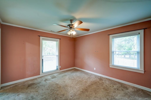 empty room featuring baseboards, ceiling fan, light colored carpet, and crown molding