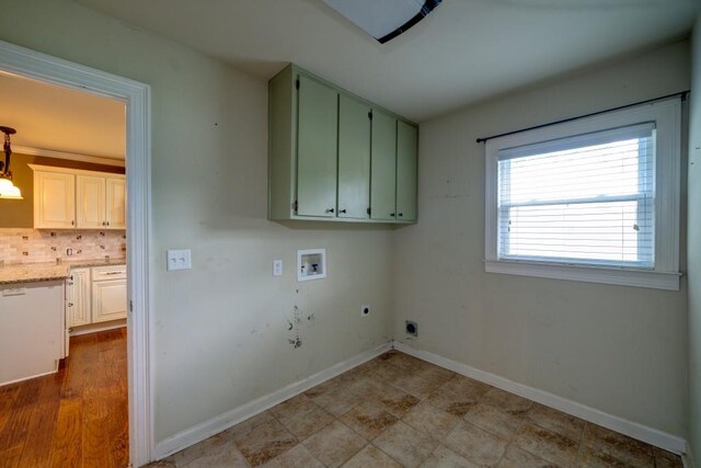 washroom with hookup for a washing machine, hookup for an electric dryer, cabinet space, and baseboards