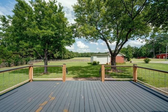 wooden terrace featuring a garage, a rural view, fence, and a yard