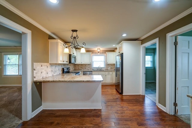 kitchen featuring stainless steel appliances, a sink, white cabinets, hanging light fixtures, and light stone countertops