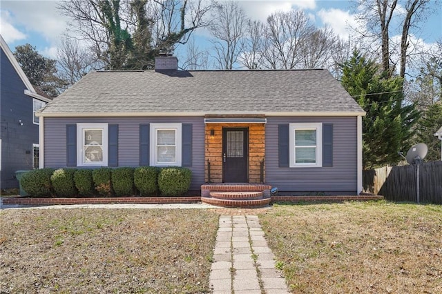 bungalow featuring a shingled roof, a chimney, a front yard, and fence