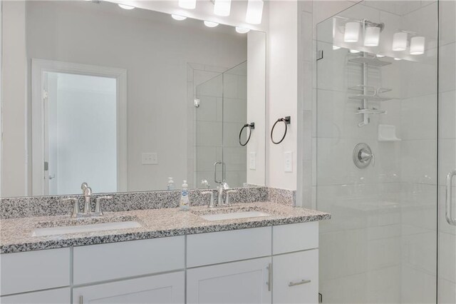 bathroom with double vanity, a stall shower, and a sink