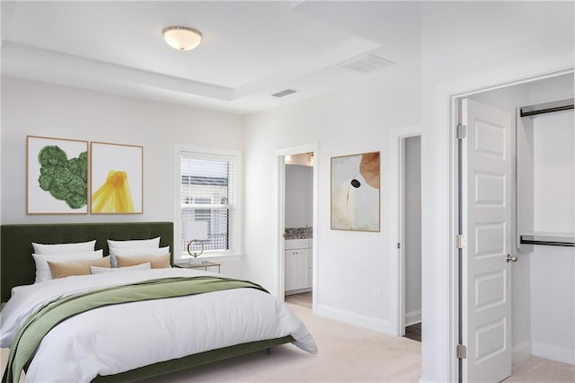 bedroom with baseboards, ensuite bathroom, visible vents, and light colored carpet