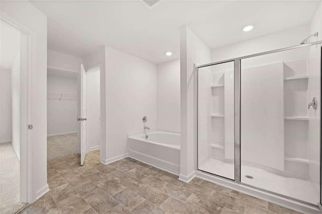1410 Aura Ln, Lawrenceville, GA 30045 - bathroom with a garden tub, a walk in closet, a stall shower, baseboards, and recessed lighting
