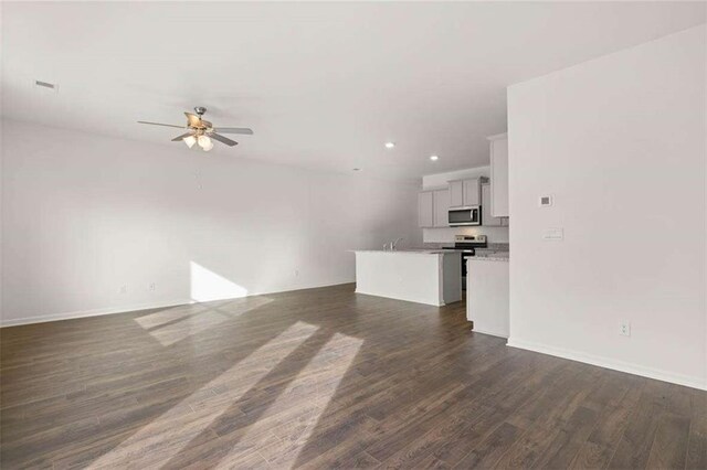 1410 Aura Ln, Lawrenceville, GA 30045 - unfurnished living room featuring ceiling fan, dark wood-type flooring, recessed lighting, a sink, and baseboards