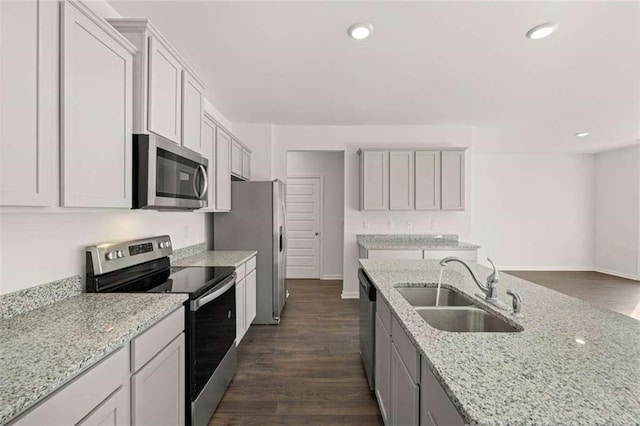1410 Aura Ln, Lawrenceville, GA 30045 - kitchen featuring appliances with stainless steel finishes, a sink, light stone countertops, dark wood finished floors, and recessed lighting