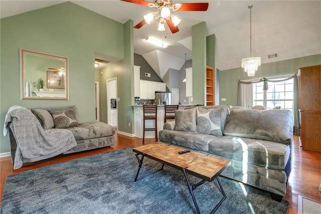 living area with wood finished floors, high vaulted ceiling, and ceiling fan with notable chandelier