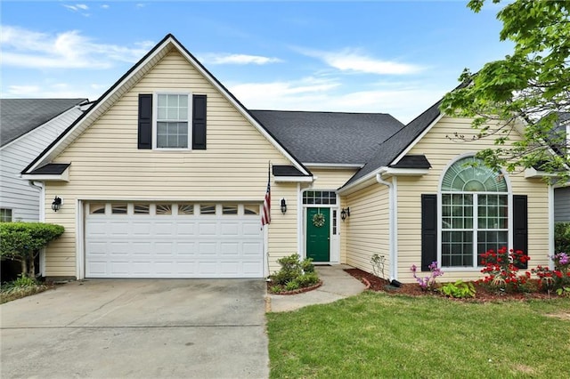 traditional-style house with concrete driveway, a shingled roof, a garage, and a front lawn