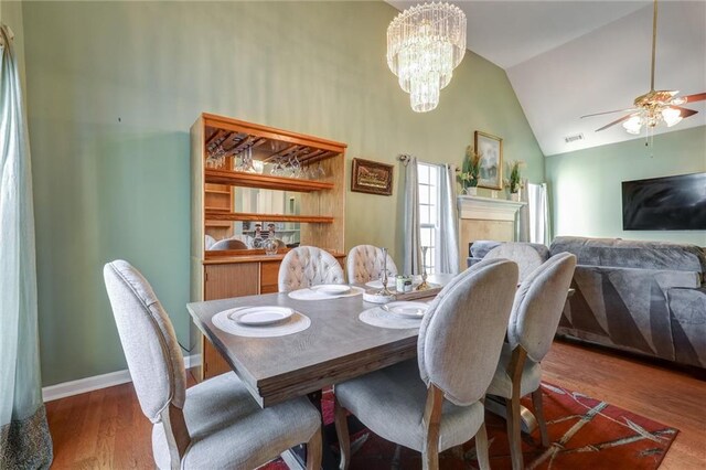 dining area with wood finished floors, high vaulted ceiling, visible vents, a ceiling fan, and baseboards