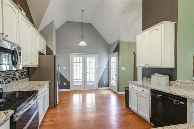 kitchen featuring stainless steel appliances, french doors, light wood finished floors, white cabinetry, and light stone countertops
