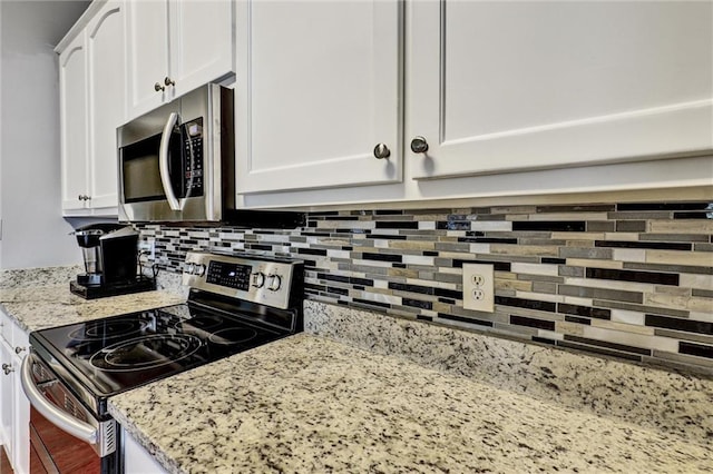 kitchen with white cabinetry, light stone counters, backsplash, and appliances with stainless steel finishes